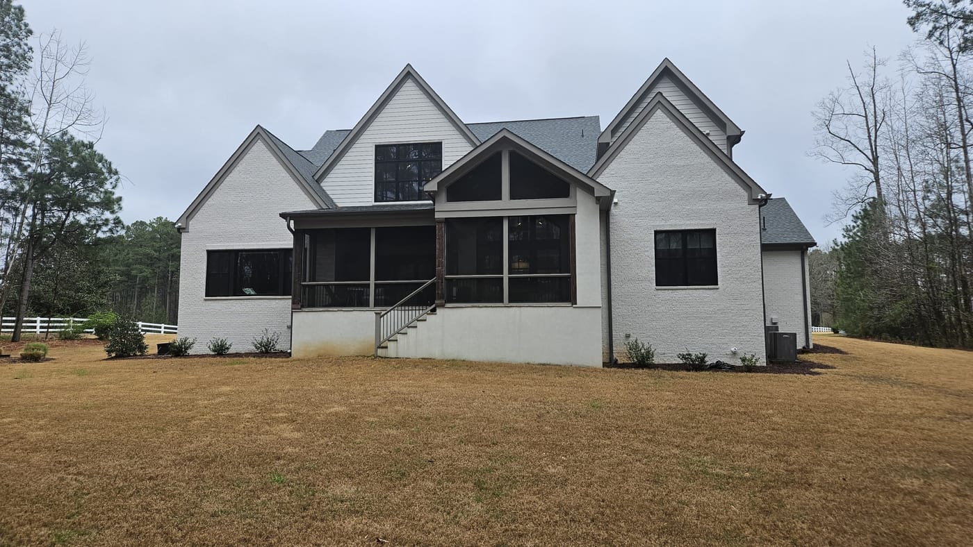 The back of a house before renovation, with a plain patio and dated exterior
